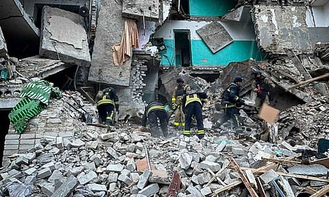 Ukrainian Emergency Services on rescue workers clear the rubble of a residential building destroyed by a Russian strike (AP)