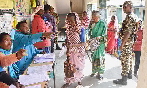 Voters wait in queues to cast votes at a polling station during the second and final phase of Jharkhand Assembly elections, at Naxal-affected Tundi constituency in Dhanbad district of Jharkhand (PTI) 