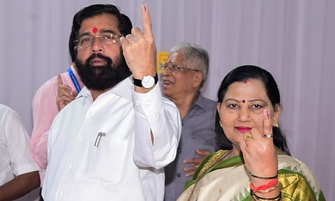  Maharashtra Chief Minister Eknath Shinde with his wife shows his ink-marked finger after casting vote during the state Assembly elections (PTI)