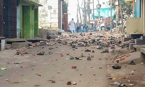 Footwears and brick bats lying on a road after violence erupted during the second survey of the Jama Masjid