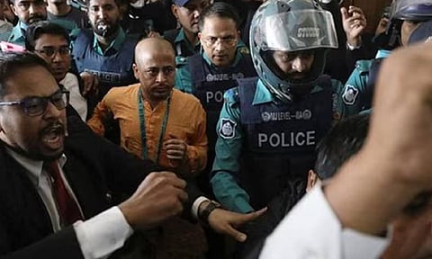 Chinmoy Krishna Das, a Hindu leader associated with the ISKCON, who faces several charges, is escorted by the police at the Chattogram Metropolitan Magistrate Court, in Chattogram (Reuters) 