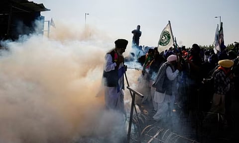 Farmers walk amidst tear gas as they gather on the day they march towards New Delhi (Reuters)
