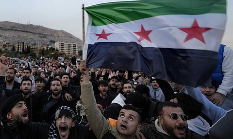 Syrian citizens wave the revolutionary flag and shout slogans (AP)