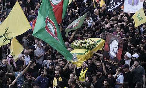 Hezbollah fighters carry one of the coffins of four fallen comrades who were killed Tuesday after their handheld pagers exploded, during their funeral procession in the southern suburb of Beirut, Lebanon. (AP Photo)