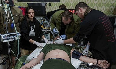 A medic treats an injured Ukrainian serviceman at Medical Service "Ulf" of the 108th Separate Battalion "Da Vinci Wolves" on Pokrovsk direction, Ukraine (AP)