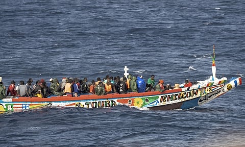 Migrants crowd a wooden boat as they sail to the port in La Restinga on the Canary island of El Hierro, Spain (AP)