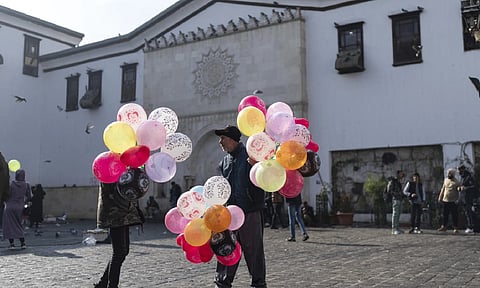 12 Balloon sellers wait for customers near Al-Hamidiyeh Souq on New Years Eve, in Damascus, Syria (AP)