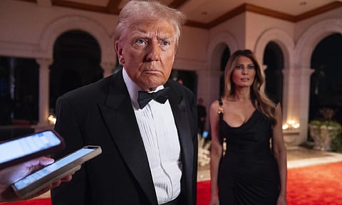 Melania Trump looks on as President-elect Donald Trump speaks to the reporters before a New Year's Eve party at Mar-a-Lago (AP Photo)