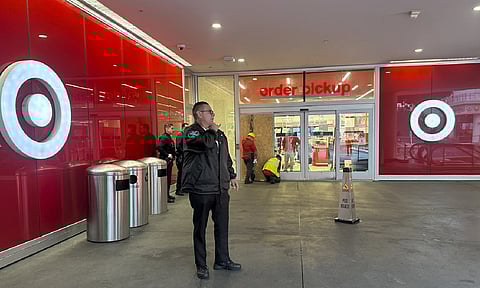 A security guard stands outside a Target store after two security guards were shot and wounded area after they confronted a man suspected of shoplifting in downtown Los Angeles (AP Photo)