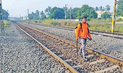 A railway worker conducts an inspection of the track after the loco pilot applied the brake near Vandalur