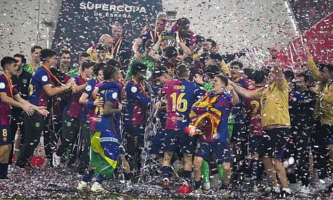 Barcelona players celebrate with their team's trophy of the Spanish Super Cup after the final soccer match between Real Madrid and Barcelona (AP)