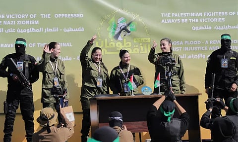 Israeli female soldier hostages wave at a Palestinian crowd before being handed over to the Red Cross in Gaza City (AP)