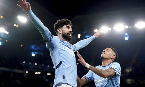 Manchester City's Josko Gvardiol, left, celebrates after his cross led to an own goal during the Champions League opening phase soccer match between Manchester City and Club Brugge at the Etihad Stadium in Manchester (AP)