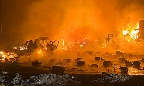 Rescue team members conduct an operation after a fire broke out following a series of blasts in a truck carrying gas cylinders, in Ghaziabad