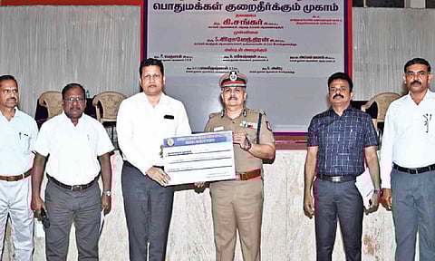 Officials handing over money recovered in cyber crime cases