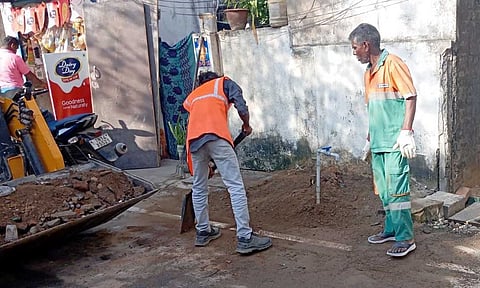 Civic body workers collecting construction debris from Kottivakkam Kuppam Road on Friday 