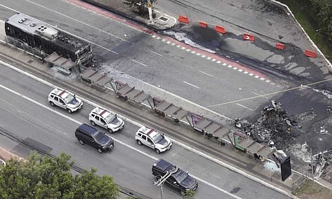 The crash site of a small plane, right, that burned a bus, left, covers an avenue in Sao Paulo (AP) 