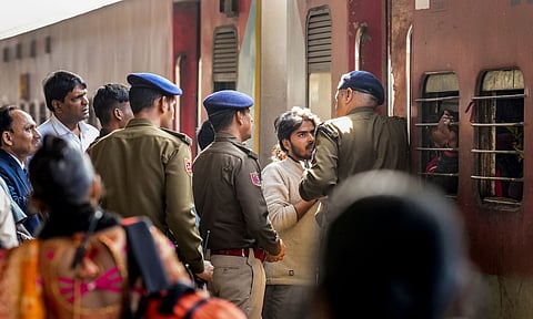 Security personnel manage passengers boarding a train at the New Delhi Railway Station (PTI)