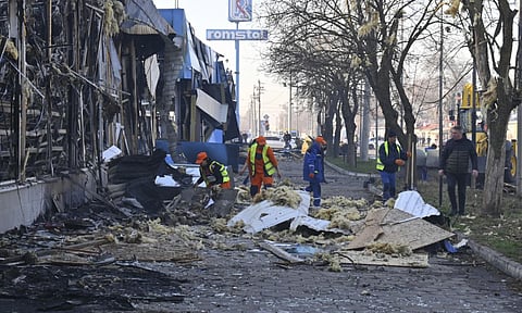Municipal workers clean up after Russian drones hit shops during the night attack in Odesa, Ukraine (AP)