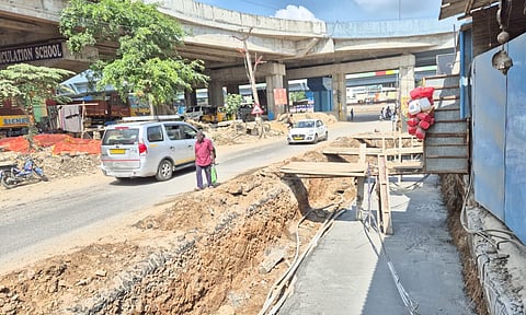 A man walking by the open construction of the stormwater drain in Perungalathur’s Sathananthapuram - Nedungundram Road