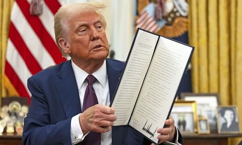 President Donald Trump holds up a signed executive order aiming to declassify remaining federal records relating to the assassinations of President John F. Kennedy, Sen. Robert F. Kennedy, and Martin Luther King Jr., in the Oval Office of the White House (AP)