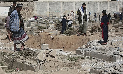 Yemenis watch a hole at Magel Al-Dammah cemetery a day after it was struck by U.S air strikes in Sanaa, Yemen (AP) 