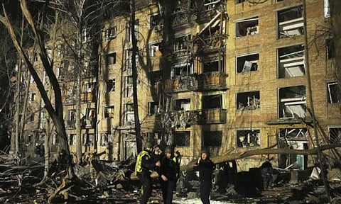 Ukrainian police officers stand near a damaged building after a Russian ballistic missile attack in Kyiv (AP)