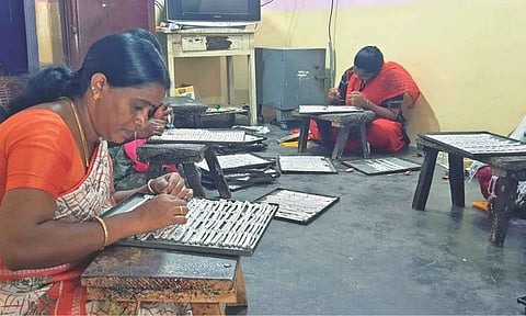 Silversmiths making anklets at a workshop in Salem 