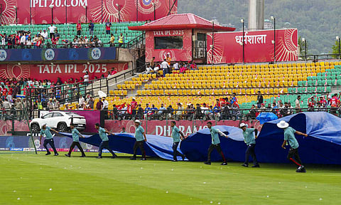 Groundsmen cover the field as it rains before the start of the Indian Premier League (IPL) 2025 match between Punjab Kings and Delhi Capitals, at Himachal Pradesh Cricket Association Stadium, in Dharamshala (PTI) 