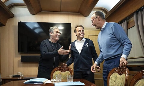 Britain’s Prime Minister Keir Starmer, left, meets with French President Emanuel Macron, center, and German Chancellor Friedrich Merz onboard a train to the Ukrainian capital Kyiv where all three will hold meetings with Ukrainian President Volodymyr Zelenskyy (AP)
