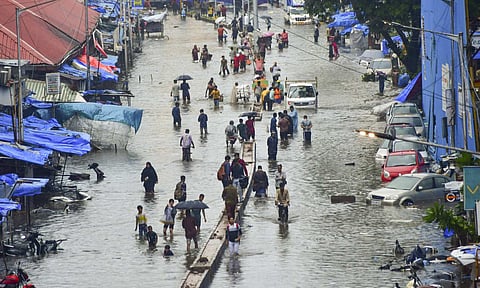 People wade through a waterlogged road amid rains at Byculla, in Mumbai, Monday, May 26, 2025 (PTI) 