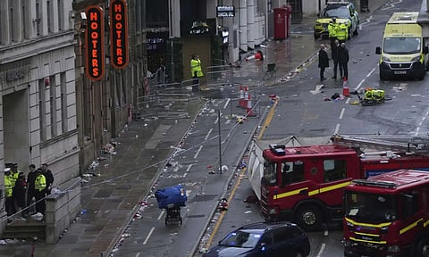 Fans leave as Police and emergency personnel deal with an incident after a car collided with pedestrians near the Liver Building during the Premier League winners parade in Liverpool (AP)