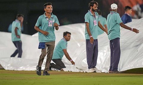 Groundsmen cover the pitch as it rains before the start of the Indian Premier League (IPL) 2025 Qualifier 2 cricket match between Mumbai Indians and Punjab Kings, at the Narendra Modi Stadium, in Ahmedabad (PTI) 