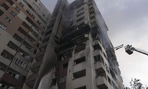 A firefighter stands on a crane at the scene of an explosion at a residence compound after Israeli attacks in Tehran, Friday, June 13, 2025 (PTI) 