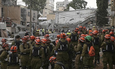 Rescue teams, police, and military personnel examine the scene of an Iranian missile strike in Bnei Brak, near Tel Aviv, Israel (AP)