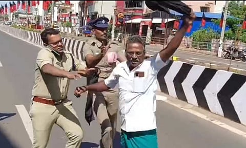 Police personnel forcibly removing farmers who were trying to wave a black flag at the Chief Minister in Thanjavur on Monday 