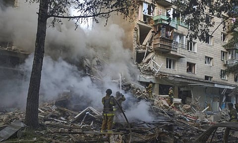 Firefighters put out the fire after a Russian missile hit a residential building during Russia's massive missile and drone air attack in Kyiv (AP)