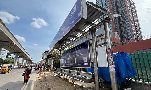 A commuter standing on the roadside to board a bus at Perungudi bus stop 