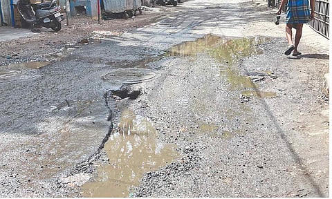 Partially open manhole on slush-filled street at West Mambalam