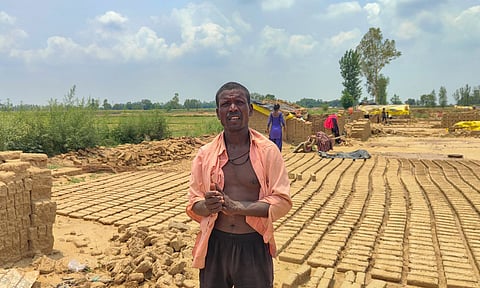 A migrant worker stands over stacks of bricks ruined by rain at a brick kiln, in Aligarh district, Uttar Pradesh (PTI)