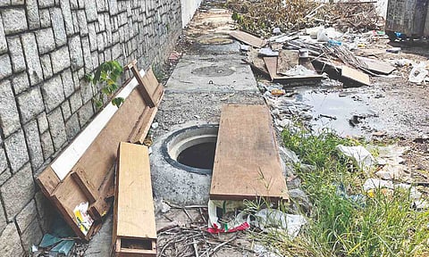 A piece of plywood covering an open SWD on the pavement