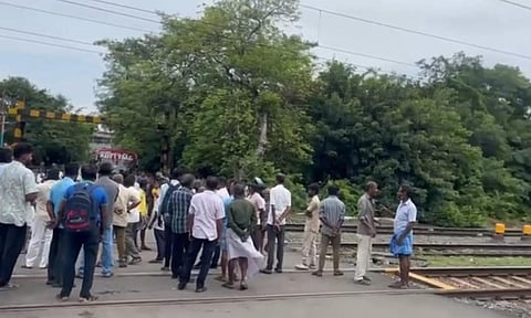 Commuters gathered on the railway track in Tirusulam as EMU traffic keeps gate closed for three hours on Saturday