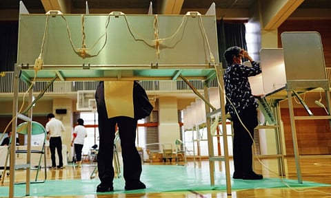 Voters fill in their ballots in the upper house election at a polling station (AP)