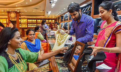 A woman tries on an ornament at a jewellery showroom on Akshay Tritya festival, in Navi Mumbai, Wednesday, April 30, 2025 (PTI) 