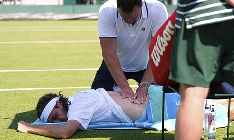 Stefanos Tsitsipas of Greece receives treatment during his first round men's single match against Valentine Royer of France at the Wimbledon Tennis Championships in London, Monday, June 30, 2025 (AP) 