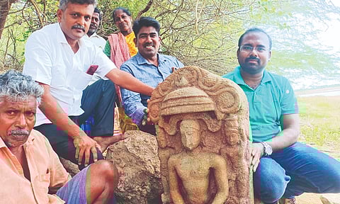 Archaeologist Manikandan and team, along with villagers with the sculpture near the bunds of the Periya Kanmai in Tirumayam