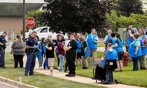 Michigan State Police officers talk to employees near the scene after a stabbing incident at a Walmart in Traverse City (AP)