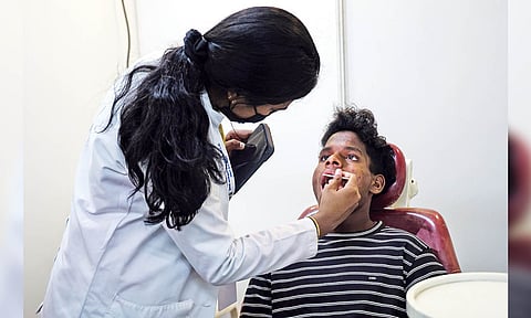 A beneficiary getting his teeth checked at the medical camp held at St Bede's Anglo Indian Higher Secondary School, Santhome 