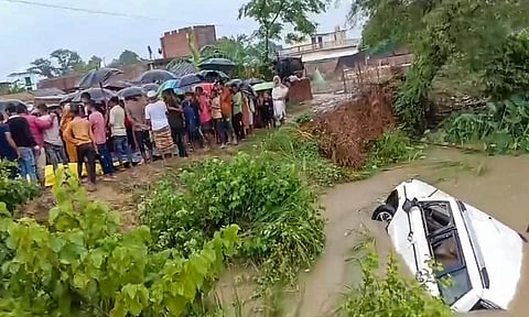 People stand near the Saryu canal after an SUV fell in the canal leaving at least 11 people dead and four others critically injured, in Gonda district, Uttar Pradesh, Sunday, Aug. 3, 2025. (PTI) 