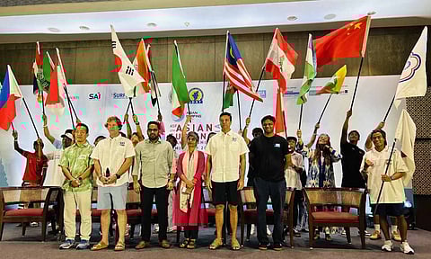 Officials and surfers onstage waving their country’s flags after the sand pouring ceremony 